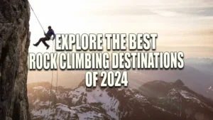 A climber rappelling down a steep cliff with a view of the sun setting over snow-capped mountains in the background.