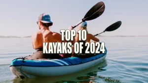 Two people paddling in a blue and white inflatable kayak on calm waters, with clear skies in the background.