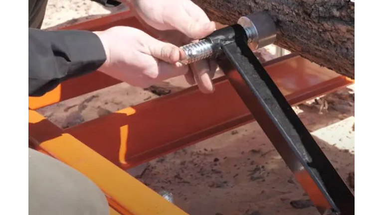 Person’s hand adjusting an orange Wood-Mizer LT15 WIDE Portable Sawmill