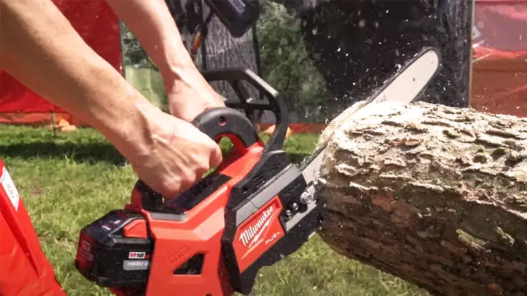 Person using a Milwaukee M18 FUEL Chainsaw to cut a log