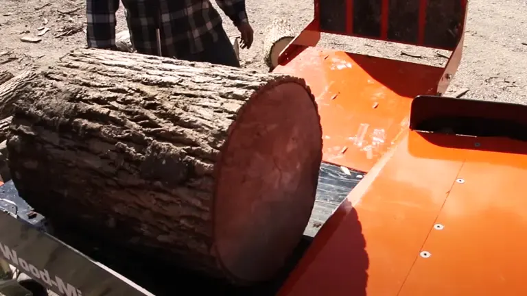 person operating a Wood-Mizer FS300 Log Splitter to split a large log