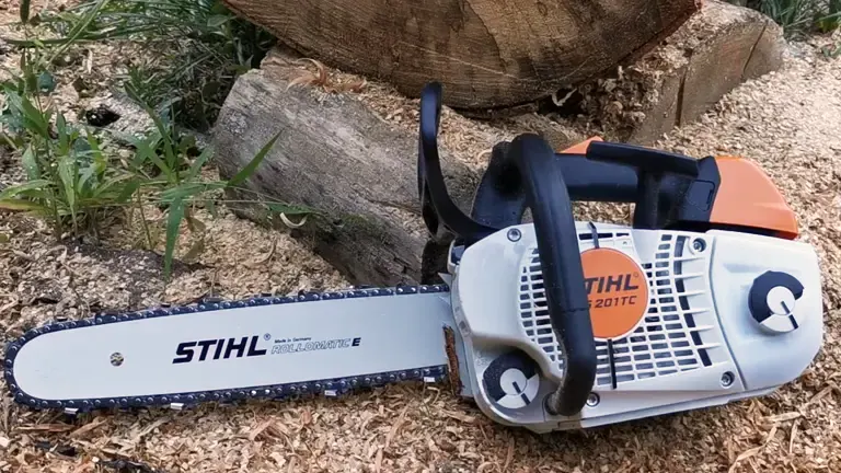Stihl MS 201 TC-M chainsaw on wood chips next to a log