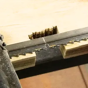 Damaged sawmill blade cutting through wood