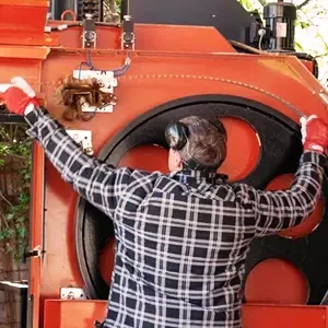 A person inspecting a large, circular sawmill blade