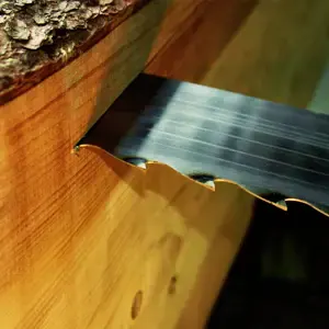 Close-up of a sharp sawmill blade cutting through wood