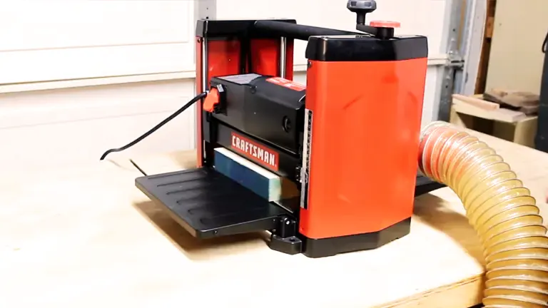 CRAFTSMAN Benchtop Planer in a clean workshop, with dust collection hose and wood planks in the background.