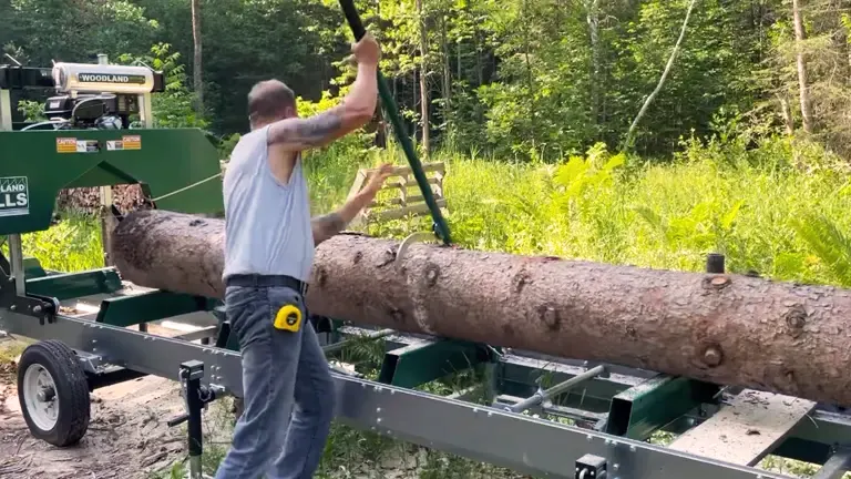 Person operating a Woodland Mills sawmill in a forested area.