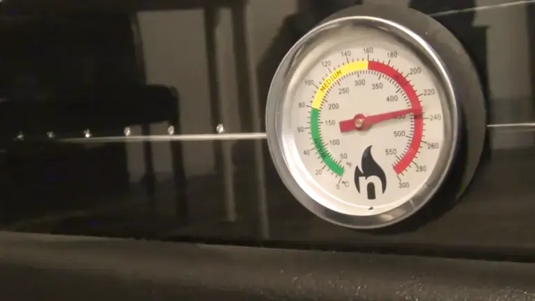 Close-up of a thermometer on a wood stove showing high temperature.