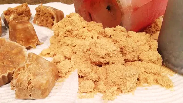 A pile of light brown sawdust next to blocks of brown soap.