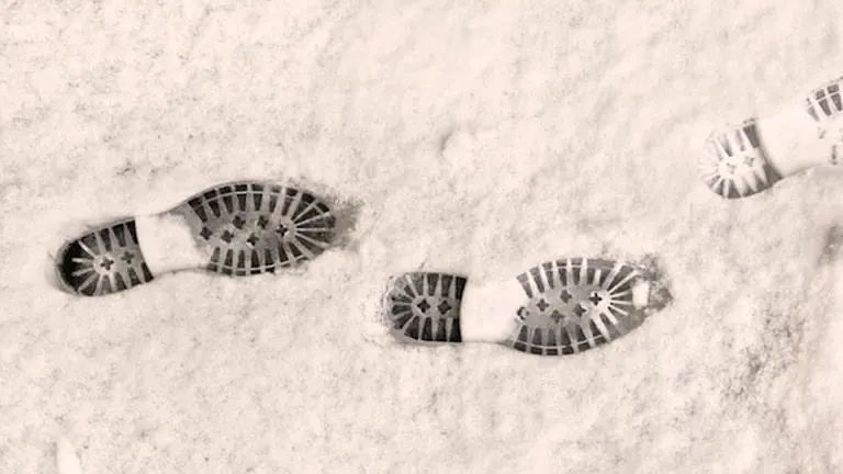 Boot footprints in powdery snow.