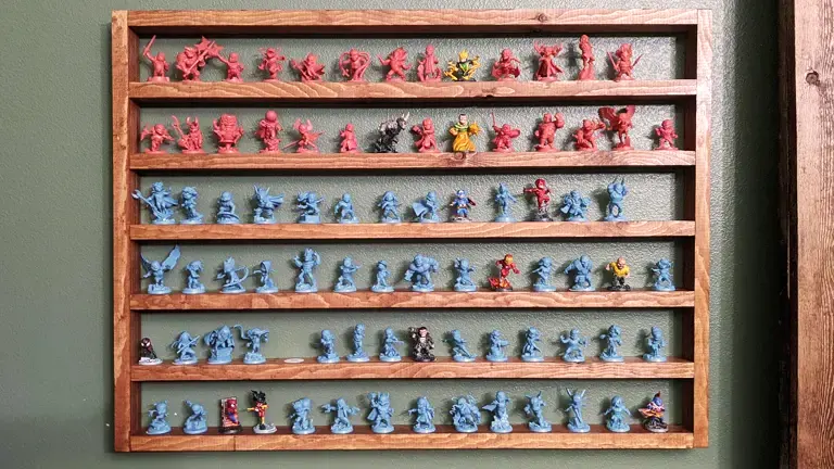 Wooden shelf displaying rows of colorful miniature figures.
