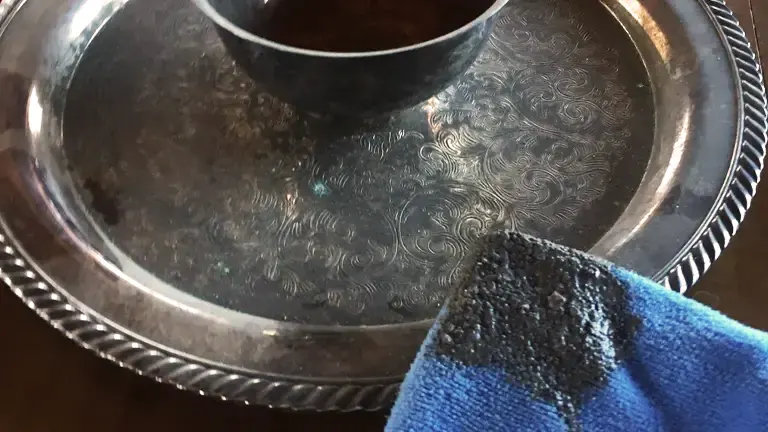 Silver tray with wood ash and a partially covering blue cloth.