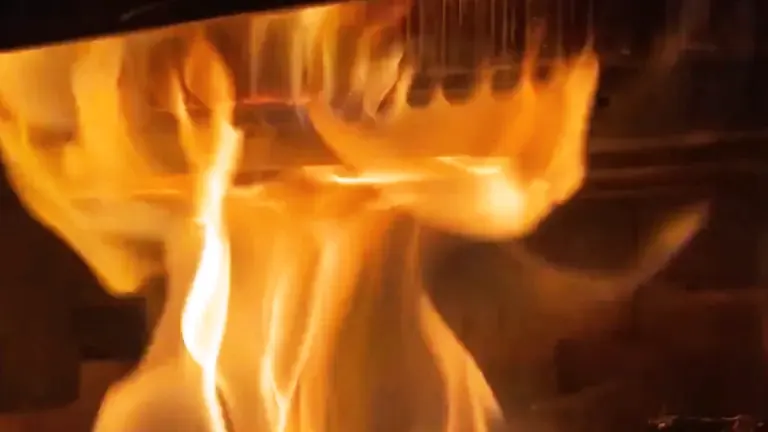 Close-up of dancing orange and yellow flames in a wood stove.