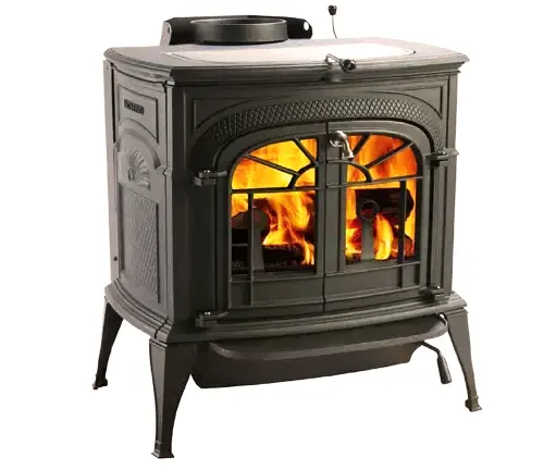 Vermont Castings wood stove with a roaring fire visible through the glass door