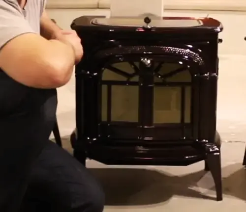 Person examining a Vermont Castings wood stove