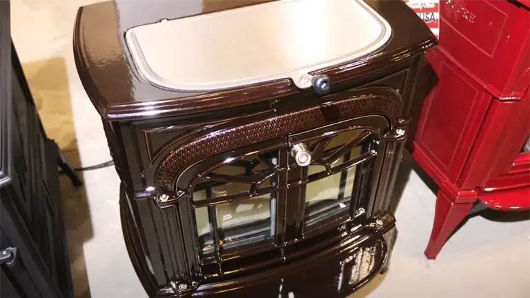 Glossy brown Vermont Castings wood stove with a cream-colored top and a glass front