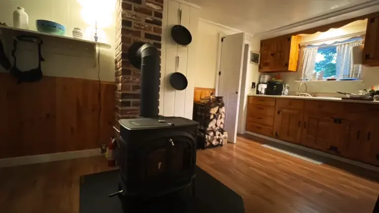 Vermont Castings wood stove in a cozy kitchen setting with neatly arranged firewood