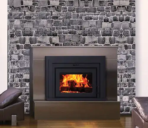 Supreme Fusion 18 Wood Burning Insert in a stone fireplace with a bright fire.