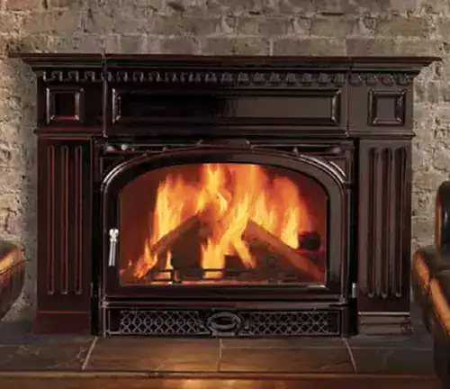 Vermont Castings Montpelier Wood Insert in a brick fireplace, with a vibrant fire.