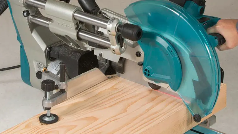 Makita LS1219L 12" Dual-Bevel Sliding Compound Miter Saw in use on wooden board.