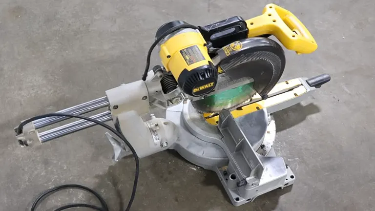DeWalt DW708 12” Double-Bevel Sliding Compound Miter Saw with green safety guard on concrete floor