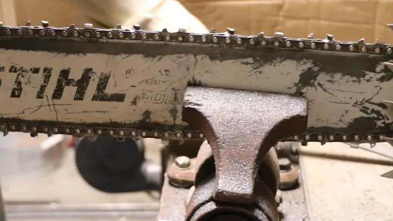 Close-up of a chainsaw blade being sharpened with a file