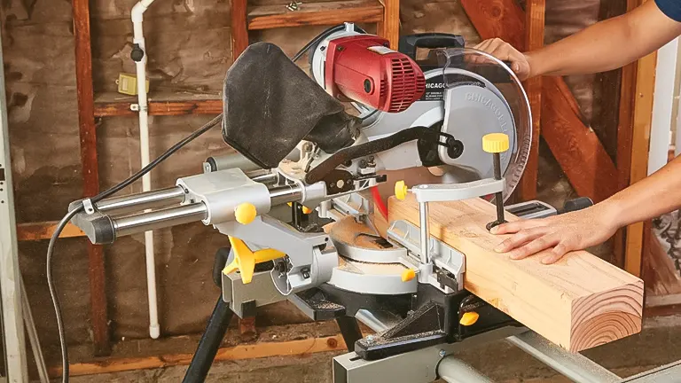 Person using Chicago Electric 61969 12” Double-Bevel Sliding Compound Miter Saw with Laser Guide System on wood.