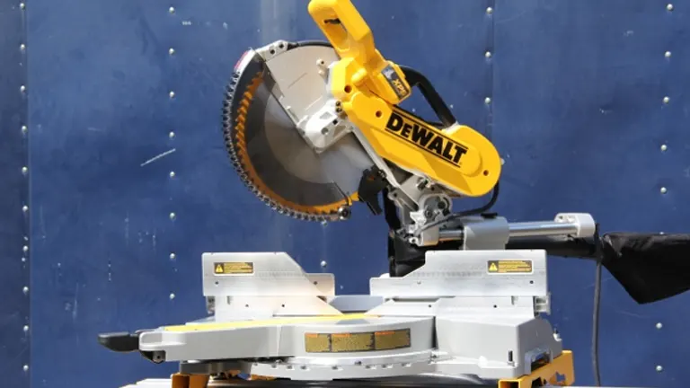 A DeWalt 12-in. Double-Bevel Sliding Compound Miter Saw with a blade in place and the saw arm extended, ready to cut a piece of wood
