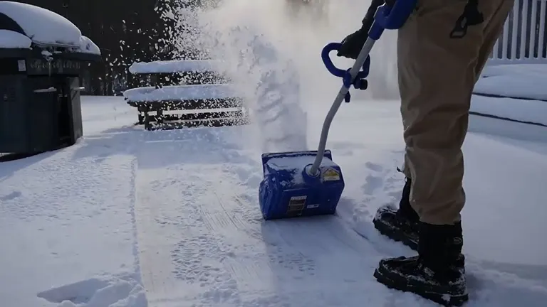 Person using Enhulk 40V 13-Inch Cordless Snow Blower to clear a patio