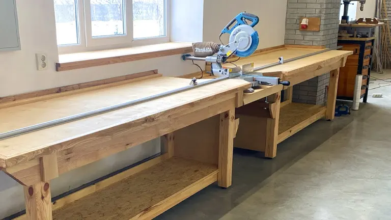 A miter saw station in a workshop with a blue miter saw and wooden table