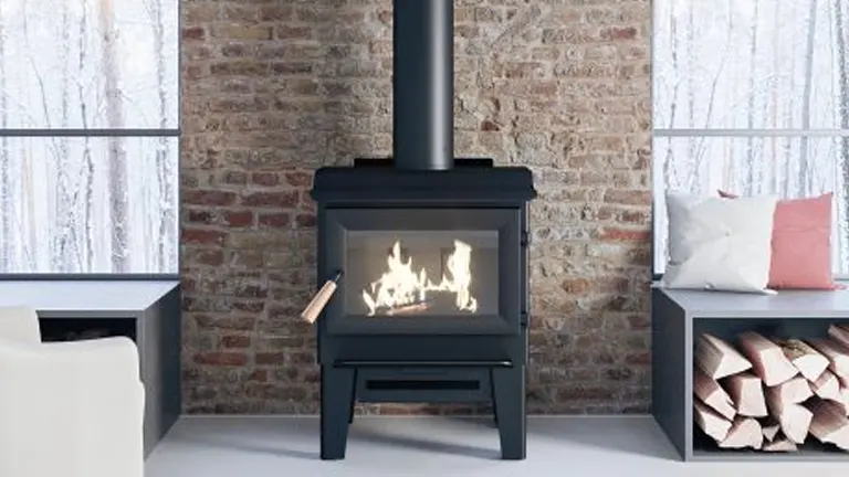 Modern wood burning stove in living room with brick wall and white furniture.