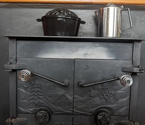 Old-fashioned stove with a pot and a kettle on top.