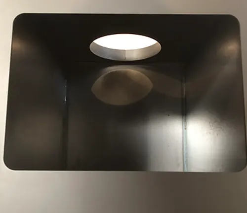 Black square light fixture with a white circular light on a white ceiling.