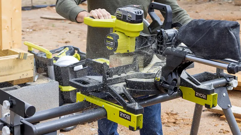Ryobi 10 in. Sliding Compound Miter Saw in action at a construction site, cutting wood with sawdust flying