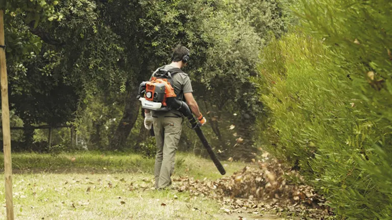 Person using Husqvarna 350BT backpack leaf blower in a garden