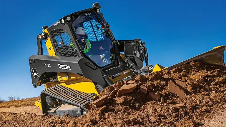 John Deere 333G Compact Track Loader moving dirt on a construction site.