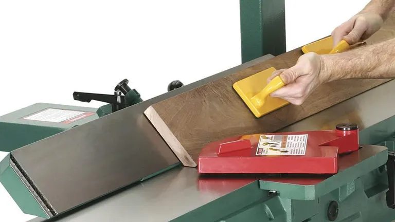 Person using Grizzly G0490X Jointer to smooth a piece of wood.