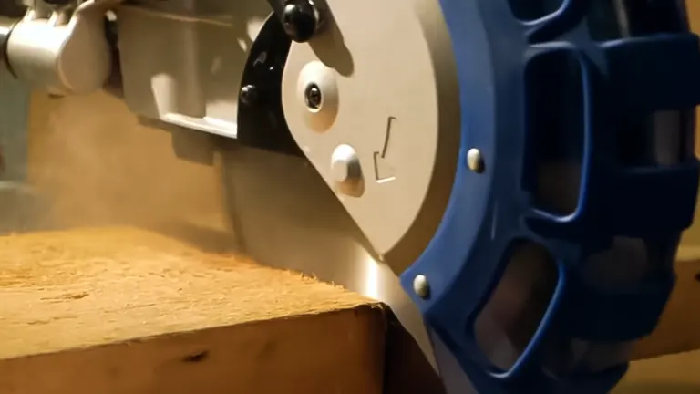 Close up of a blue and silver Draper Expert 79901 SMS305E 230V 305mm Double Bevel Sliding Compound Miter Saw cutting through wood