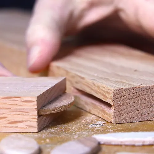 Close up of a biscuit joint being made with two pieces of wood