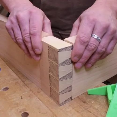 Close up of hands holding a wooden dovetail joint