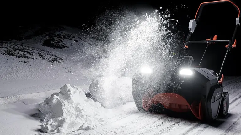 AIVOLT 40V Battery Powered Snow Blower in action on a snowy night
