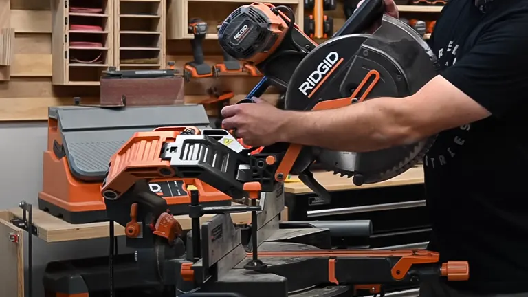 Person adjusting Ridgid R4251 12" Dual-Bevel Sliding Miter Saw in a workshop