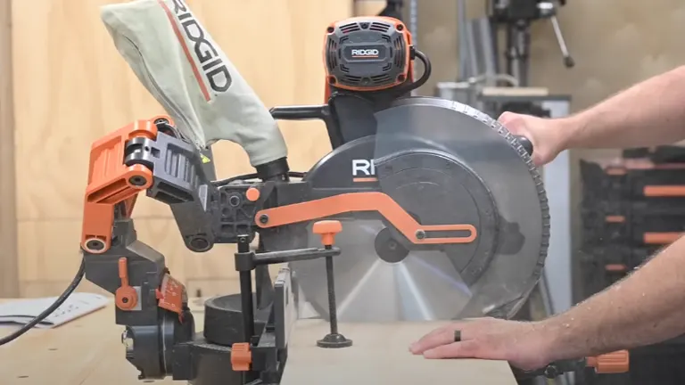 Person using Ridgid R4251 12" Dual-Bevel Sliding Miter Saw to cut wood in a workshop
