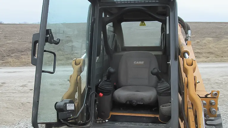 Orange Case skid steer loader with a bucket attachment parked on a snowy field.