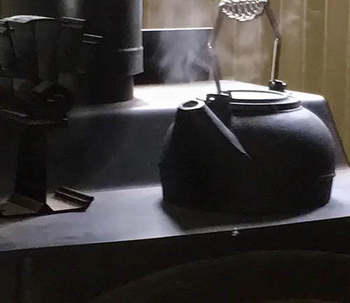 Black kettle steaming on a stovetop.