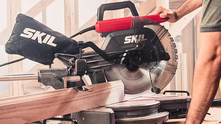Person using Skil MS6305-00 10” Dual Bevel Sliding Compound Miter Saw on a wooden plank