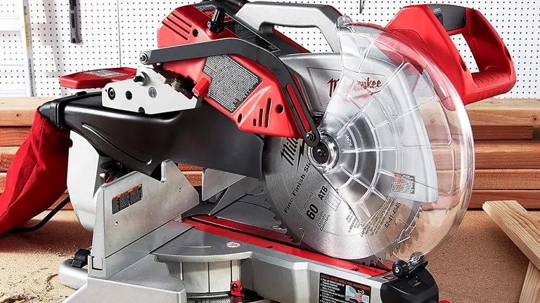 Red and black Milwaukee 6955-20 12” Dual-Bevel Sliding Compound Miter Saw with a silver blade on a workbench, with wood in the background