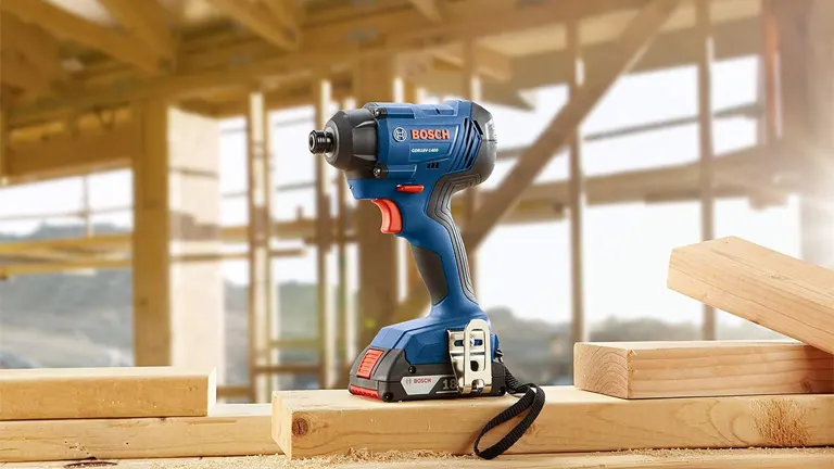 BOSCH GDR18V-1860CB25 18V Hex Impact Driver on a wooden surface at a construction site.