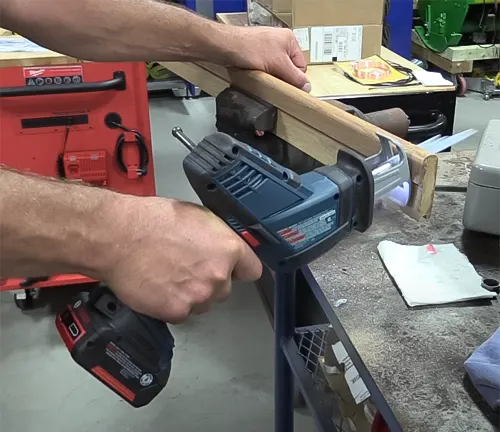 A person using a BOSCH GSA18V-083B 18V Compact Reciprocating Saw in a workshop