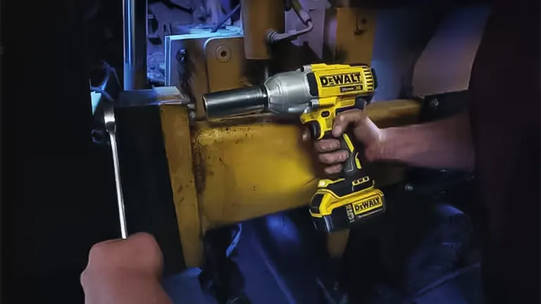 Person using a yellow DeWalt drill on a machine.